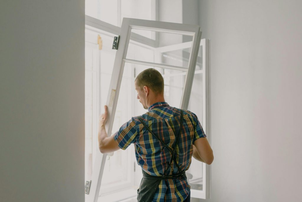 pexels photo 5691531 5691531 A professional installer fitting a modern window in a well-lit home interior.